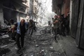 イスラエル軍による人質救出作戦で損傷した建物と散乱したがれきの中を移動する人々。パレスチナ自治区ガザ地区中部ヌセイラット避難民キャンプで（2024年6月8日撮影）。(c)Bashar TALEB / AFP