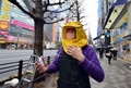 東京都の電器店サンコー（Thanko）が販売する「花粉ブロッカー」を着用してみせる同店のスタッフ（2014年3月5日撮影）。(c)AFP/Yoshikazu TSUNO