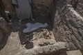 エジプト・ルクソール近郊で発見された古代都市遺構で、動物の骨にカバーをかける作業員（2021年4月10日撮影）。(c)Khaled DESOUKI / AFP