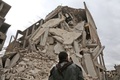 シリアの首都ダマスカス近郊の東グータ地区で、崩壊した建物のそばに立つ若者（2018年2月28日撮影）。(c)AFP PHOTO / ABDULMONAM EASSA