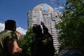 ロシア・モスクワで、無人機攻撃を受けた集合住宅を見る警備員（2023年5月30日撮影）。(c)Kirill KUDRYAVTSEV / AFP