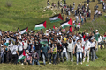 イスラエルが占領するゴラン高原（Golan Heights）のマジャルシャムス（Majdal Shams）で、パレスチナ国旗を掲げてシリア側からイスラエル側に向かうデモ隊（2011年5月15日撮影）。(c)AFP/JACK GUEZ