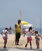 夏本番を迎えたブラジル・リオデジャネイロ（Rio de Janeiro）は22日、気温が36度以上まで上がった。

写真は、ブラジル・リオデジャネイロ（Rio de Janeiro）のコパカバーナ（Copacabana）ビーチで子どもたちにホースで水をかける男性（2009年12月22日撮影）。(c)AFP/VANDERLEI ALMEIDA