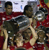 サッカーリベルタドーレス杯2010（Copa Libertadores de America 2010）は18日、決勝の第2戦がブラジルのポルトアレグレ（Porto Alegre）で行われ、インテルナシオナウ（Internacional、ブラジル）がCDグアダラハラ（Club Deportivo Guadalajara、メキシコ）を3-2で下し、2試合合計5-3で2度目の優勝を果たした。写真は優勝し、トロフィーを掲げるインテルナシオナウのアンドレス・ダレッサンドロ（Andres D&apos;Alessandro）。（2010年8月18日撮影）(c)AFP/ANTONIO SCORZA