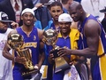 2001-02シーズンのNBAファイナルを制し、トロフィーを手にポーズをとるロサンゼルス・レイカーズのコービー・ブライアント（左）とシャキール・オニール（右、2002年6月12日撮影）(c)AFP/HENNY RAY ABRAMS