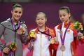 ロンドン五輪体操女子種目別、平均台決勝。表彰式でメダルを掲げる（左から）銅メダルのアレクサンドラ・レイズマン（Alexandra Raisman）、金メダルのトウ琳琳（Deng Linlin）、銀メダルのスイ禄（Sui Lu、2012年8月7日撮影）。(c)AFP/EMMANUEL DUNAND