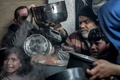 パレスチナ自治区ガザ北部ベイトラヒヤで、配給食料を求めて集まった地域住民（2024年2月26日撮影）。(c)AFP