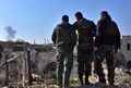 シリア北部アレッポの市内から立ち上る煙を見る政府軍側の部隊（2016年12月9日撮影）。(c)AFP/George OURFALIAN