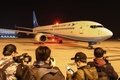 中国・武漢の空港で、タイの首都バンコクから到着したアモイ航空機から湖北省出身者が降りるのを待つ記者たち（2020年1月31日撮影）。(c)AFP