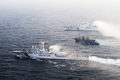 韓国沖の黄海（Yellow Sea）で21日、違法操業中に韓国海洋警察庁による取り締まりを受けた中国漁船12隻が、船体を互いにロープで縛ってひとかたまりの大船団を作り上げ、逃走を図った。黄海の韓国の排他的経済水域（EEZ）では中国漁船による密漁が常態化しており、海洋警察庁によると過去1年に332隻を拿捕したという（2010年12月21日撮影）。(c)AFP/PARK YOUNG-CHUL
