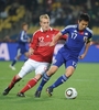 2010年サッカーW杯南アフリカ大会（%%2010 World Cup%%）1次リーグE組、デンマーク対日本。日本は3-1で勝利し、勝ち点6（2勝1敗）の同組2位で決勝トーナメントに進んだ。日本の決勝トーナメント進出は、自国開催以外のW杯では初めて。写真はデンマークのトマス・カフレンベルグ（%%Thomas Kahlenberg%%）と競り合う日本の長谷部誠（%%Makoto Hasebe%%、右）。（2010年6月24日撮影）(c)AFP/GABRIEL BOUYS