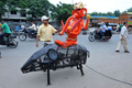 インド・ハイデラバード（Hyderabad）の路上を歩く、ネズミにまたがったヒンズー教の神ガネーシャ（Ganesh）のロボットと、制作者でデザイナーのスダカール・ヤダブ（Sudhakar Yadav）氏（2012年9月18日撮影）。(c)AFP/Noah SEELAM