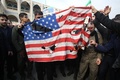 イラン首都テヘランで「米国の犯罪」に抗議し米国旗を燃やす人々（2020年1月3日撮影）。(c)ATTA KENARE / AFP