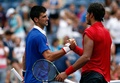 全米オープンテニス、男子シングルス1回戦。試合後、ジョアン・ソウザ（右）と握手を交わすノバク・ジョコビッチ（2015年8月31日撮影）。(c)AFP/Getty Images/Michael Heiman