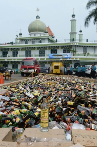 1万本以上の酒瓶をローラー重機で破砕、インドネシア