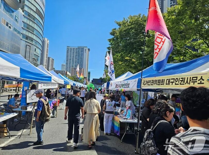 韓国・大邱市中心部でクィア文化祭を前に設置された広報ブースの通路を行き交う市民(c)news1