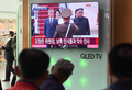 北朝鮮の平壌に到着した韓国の文在寅大統領と、出迎えた北朝鮮の金正恩朝鮮労働党委員長を映したテレビ画面（2018年9月18日撮影）。(c)Jung Yeon-je / AFP