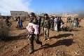 シリア北部アレッポで、戦闘を逃れ、政府軍側部隊が管理する検問所に集まる住民（2016年12月8日撮影）。(c)AFP/Youssef KARWASHAN