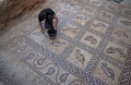 パレスチナ自治区ガザ地区で、ビザンツ帝国時代のモザイク画を清掃する発見者の男性の息子（2022年9月18日撮影）。(c)MOHAMMED ABED / AFP