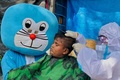 インドのムンバイ（旧ボンベイ）のスラム街で、NGOが実施した子どものヘアカット（2021年5月24日撮影）。(c)Sujit Jaiswal / AFP