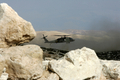 パレスチナ自治区ヨルダン川西岸（West Bank）のヘブロン（Hebron）近郊で、墜落したイスラエル空軍の戦闘機の残がいを捜索する同軍のヘリコプター（2009年9月13日撮影）。(c)AFP/HAZEM BADER