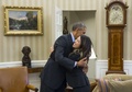 米ワシントンD.C.（Washington D.C.）ホワイトハウス（White House）の大統領執務室（Oval Office）で、エボラ出血熱から回復した看護師のニーナ・ファム（Nina Pham）さん（右）を抱きしめるバラク・オバマ（Barack Obama）米大統領（左、2014年10月24日撮影）。(c)AFP/Saul LOEB
