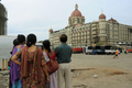 インド・ムンバイ（Mumbai）で発生した同時襲撃事件の現場の一つ、タージマハル・ホテル（Taj Mahal Hotel）を眺めるインド人家族（2008年11月30日撮影）。(c)AFP/PEDRO UGARTE