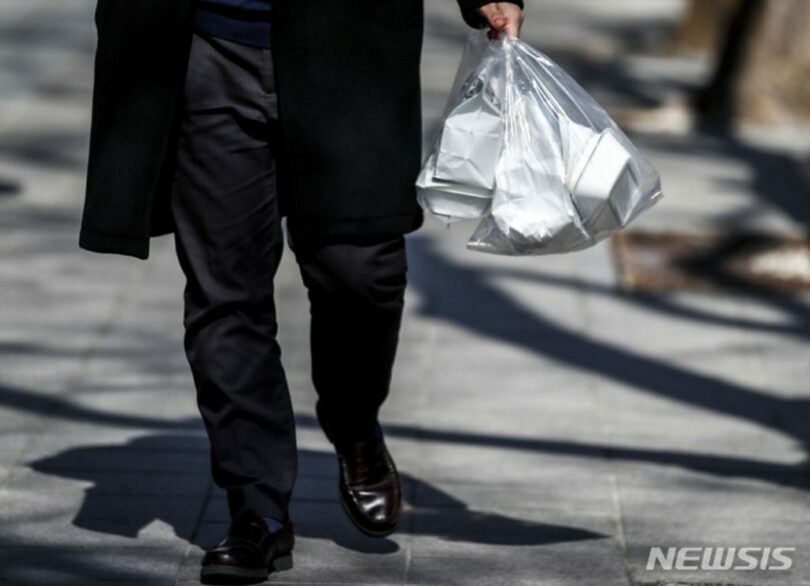 ソウルで市民が食べ物を持って歩いている(c)NEWSIS
