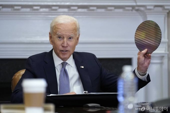 2021年4月12日、半導体供給網の復元に関するテレビ会議に参加し、半導体ウエハーを掲げるバイデン米大統領（AP）(c)NEWSIS