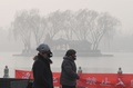 スモッグに覆われた中国・北京の湖畔を歩く人々（2017年1月1日撮影）。(c)AFP/GREG BAKER