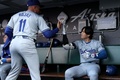24MLB、サンフランシスコ・ジャイアンツ対ロサンゼルス・ドジャース。試合開始を前にミゲル・ロハス（左）とハイタッチを交わすロサンゼルス・ドジャースの大谷翔平（2024年5月13日撮影）。(c)Ezra Shaw/Getty Images/AFP