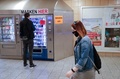 ドイツ首都ベルリンで、マスクを着けて歩く人と自動販売機でマスクを購入する人（2020年4月27日撮影）。(c)Odd ANDERSEN / AFP