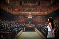 英ロンドンで、競売に先立ち報道関係者に公開されたバンクシーの絵画「退化した議会」の前に立つギャラリー職員（2019年9月27日撮影）。(c)Tolga Akmen / AFP
