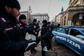 イタリア・ミラノで、スカラ座の入り口に液体をかけた環境保護団体「ラスト・ジェネレーション」の活動家を拘束する警察（2022年12月7日撮影）。(c)Piero CRUCIATTI / AFP