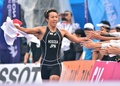 第17回アジア競技大会（17th Asian Games、Asiad）トライアスロンの混合リレーで、国旗を手に走る細田雄一（Yuichi Hosoda、2014年9月26日撮影）。(c)AFP/JUNG YEON-JE