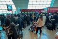 アラブ首長国連邦（UAE）のドバイ国際空港で、接続便カウンターに列をつくる人々（2024年4月17日撮影）。(c)AFP