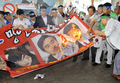 韓国ソウル（Seoul）の金浦空港（Gimpo airport）で、自民党の新藤義孝（Yoshitaka Shindo）衆院議員、稲田朋美（Tomomi Inada）衆院議員、佐藤正久（Masahisa Sato）参院議員の写真を燃やして3人の鬱陵島訪問計画に抗議する活動家ら（2011年8月1日撮影）。(c)AFP/JUNG YEON-JE