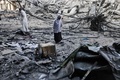 パレスチナ自治区ガザ地区で、イスラエルの空爆で破壊されたアルシュルク・タワーの近くを歩く市民（2021年5月13日撮影）。(c)MOHAMMED ABED / AFP