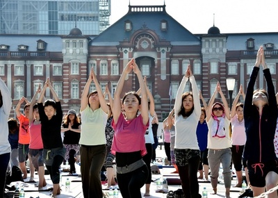 東京駅前で早朝野外ヨガ、100人汗流す