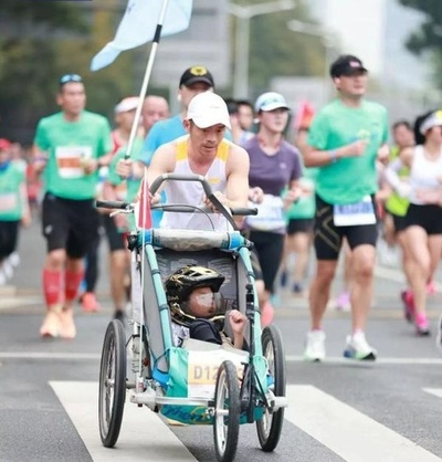 てんかん患者の息子を三輪カートに乗せて56回目のマラソンを完走 中国・深セン