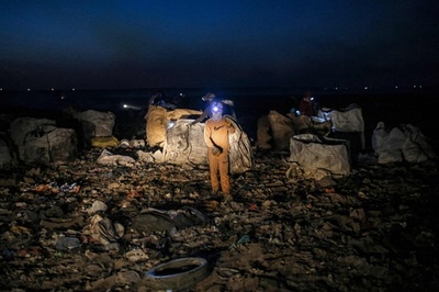 【今日の1枚】煙くすぶる埋め立て地で夜間探索 イラク