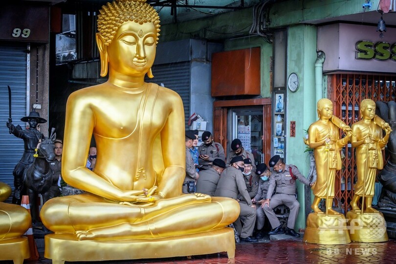 【今日の1枚】仏の慈悲の雨宿り、タイの警察官