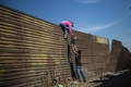 メキシコ北部ティフアナのエルチャパラルで、米国境のフェンスを越えようとする中米移民（2018年11月25日撮影）。(c)Pedro PARDO / AFP