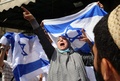中東エルサレム旧市街で、イスラエル国旗を掲げたユダヤ人デモ隊に抗議するパレスチナ人女性（2022年5月29日撮影）。(c)HAZEM BADER / AFP