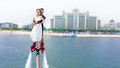 フライボードに乗って結婚式に現れた新郎新婦（2020年5月18日撮影）。(c)Xinhua News