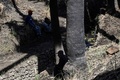 ペルー南部の砂漠地帯にあるナスカ時代の送水路の一部に腰かけて休む人たち（2023年5月17日撮影）。(c)Ernesto BENAVIDES / AFP