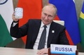 オンライン形式で開かれた新興5か国（BRICS）首脳会議にモスクワから出席し、「乾杯」のしぐさを見せるロシアのウラジーミル・プーチン大統領（2022年6月23日撮影）。(c)Mikhail Metzel / SPUTNIK / AFP