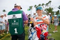 女子ゴルフ米国ツアー、ピュアシルクバハマLPGAクラシック初日。ラウンド前に緑のビブスを贈呈されたキャディーのジェイソン・ハミルトン氏と一緒にポーズをとるリディア・コー（2015年2月5日撮影）。(c)AFP/Getty Images/Tom Pennington