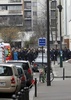 銃撃のあった仏パリ（Paris）にある風刺週刊紙シャルリー・エブド（Charlie Hebdo）の本社前に集まる警察官と消防隊員（2015年1月7日撮影）。(c)AFP/KENZO TRIBOUILLARD