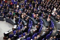 ドイツの首都ベルリンの連邦議会で、極右政党「ドイツのための選択肢（AfD）」の議員ら（写真手前）以外から、首相選出後に拍手を浴びるアンゲラ・メルケル氏（2018年3月14日撮影）。(c)AFP PHOTO / John MACDOUGALL